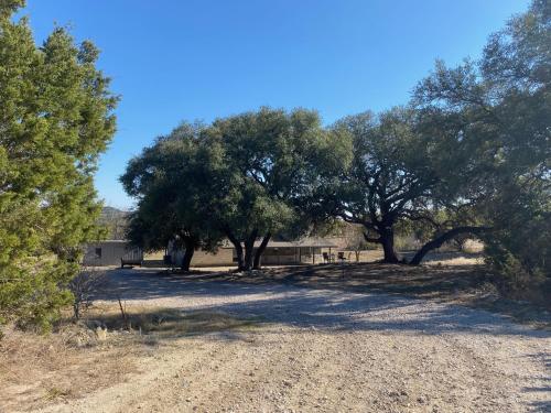 un grupo de árboles en un camino de tierra en Texas Hill Country Ranch House - Great Views - Near Hidden Falls Park, en Smithwick
