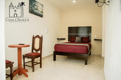 1 dormitorio con 1 cama, 1 silla y 1 mesa en Casa Chenera, en Campeche