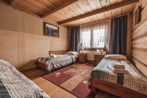 a bedroom with three beds in a room with a window at U Skowyrów in Gliczarów