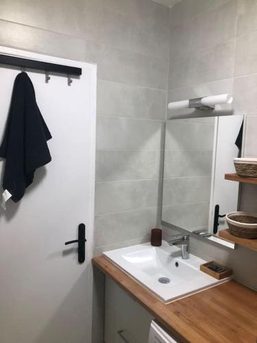 une salle de bain avec un lavabo et un miroir dans l'établissement Appartement vue mer au Lavandou, au Lavandou