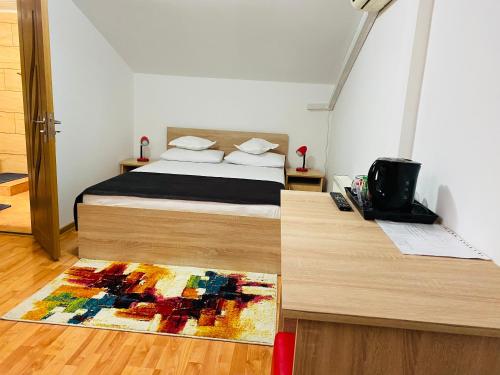a bedroom with a bed and a rug on the floor at Casa Adriana in Băile Herculane
