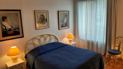 a bedroom with a blue bed and two chairs at Chez Jeanne in Carentan