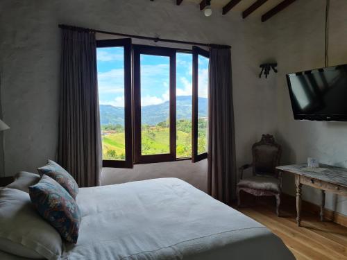 a bedroom with a bed and a window with a view at Casa Santamaria Hotel Campestre in Jericó