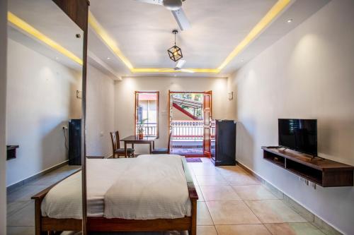 ein Schlafzimmer mit einem Bett und einem TV in einem Zimmer in der Unterkunft Whiteboard Homes Siolim in Siolim