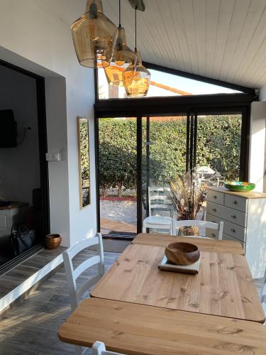 - une table et des chaises en bois dans une chambre avec fenêtre dans l'établissement Location maison de vacances à Sainte-Marie-Plage, à Sainte-Marie-la-Mer