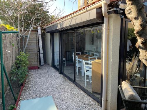 une extension du patio avec des portes en verre sur une maison dans l'établissement Location maison de vacances à Sainte-Marie-Plage, à Sainte-Marie-la-Mer