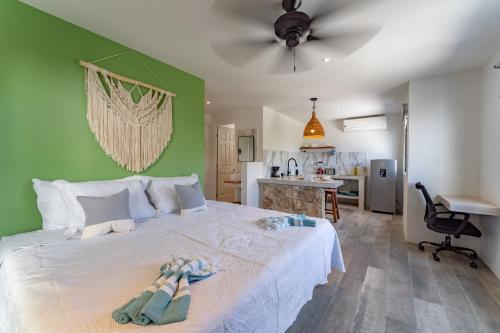 a bedroom with a white bed and a green wall at Casa Yako in Playa del Carmen