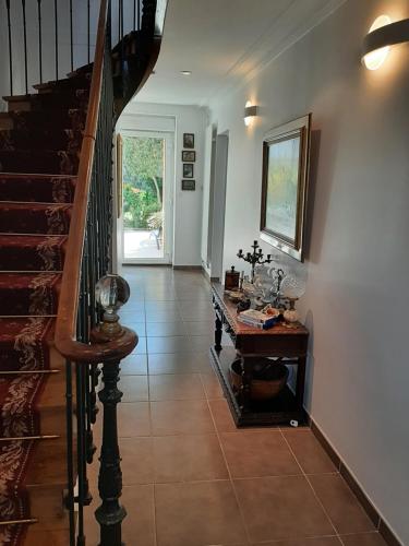 a hallway with a staircase and a table on a tile floor at Chez Jeanne in Carentan
