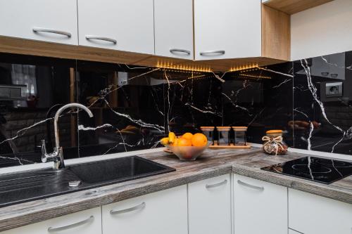 a kitchen with a sink and a bowl of oranges at Glicinia in Šibenik