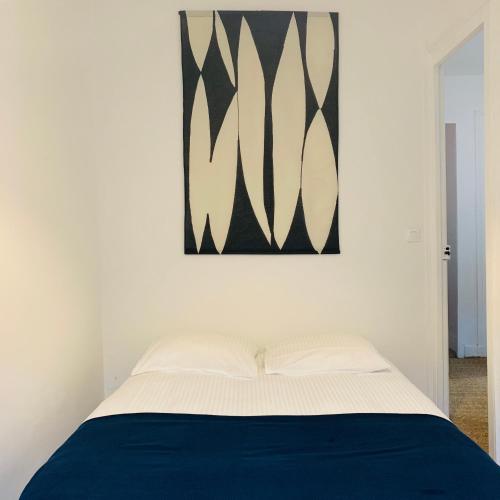 トゥルヴィル・シュル・メールにある3 PIECES PLEIN CENTREのベッドルーム1室(壁に絵画が描かれたベッド1台付)