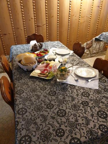 a table with food and plates of food on it at Skowyrowe Wzgórze - Pokoje z pięknym widokiem na góry in Gliczarów