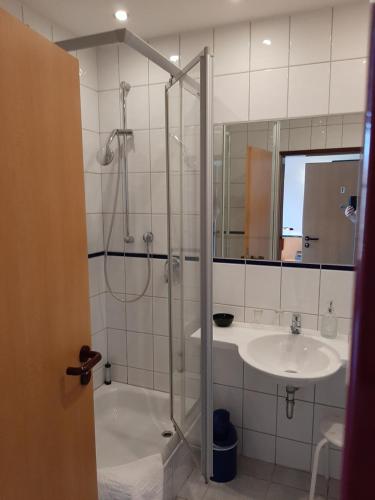 La salle de bains est pourvue d'une douche et d'un lavabo. dans l'établissement Hotel & Restaurant Eichholz, à Cassel