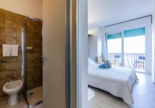 a bedroom with a bed and a bathroom with a balcony at Eurhotel in Rimini