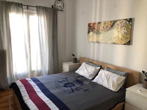 sypialnia z łóżkiem i obrazem na ścianie w obiekcie Cosy apartment in Metaxourgeio w Atenach