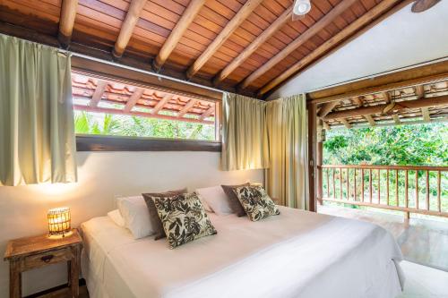 a bedroom with a white bed and two windows at Solar Pitanga - Taipu de Fora in Barra Grande