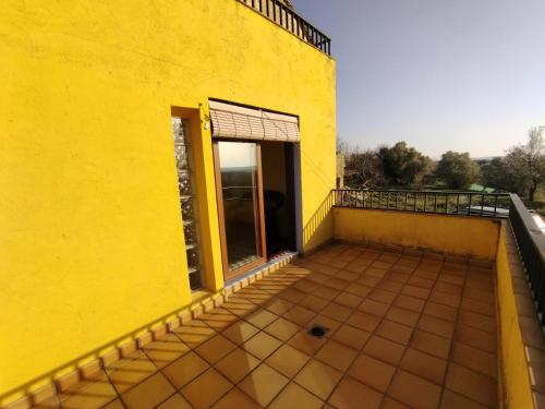 a yellow building with a door on a balcony at Casa el Sereno in Salas Bajas