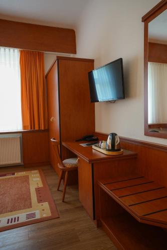 a hotel room with a desk with a television on it at Hotel Seeschlösschen in Groß Köris