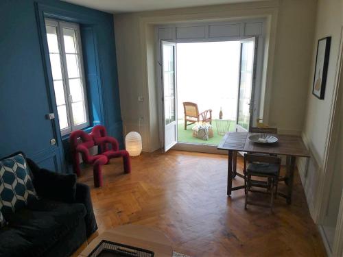 un salon avec un canapé, une table et des chaises dans l'établissement Appartement de standing - avec terrasse et vue mer, à Arromanches-les-Bains