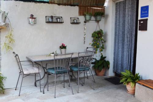 una mesa y sillas en un patio con plantas en Apartment Fjaka en Sali