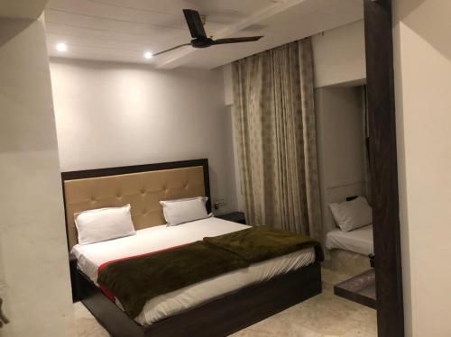 a bedroom with a bed with a ceiling fan at Hotel Rani Palace in Udaipur