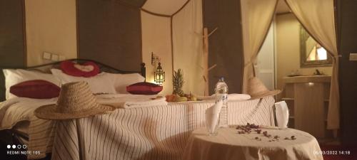 um quarto com uma cama grande com duas mesas e uma cama sem acabamentos em Sahara Tours luxury camp em Merzouga