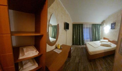 a hotel room with a bed and a mirror at Pensiunea La Palia in Iaşi