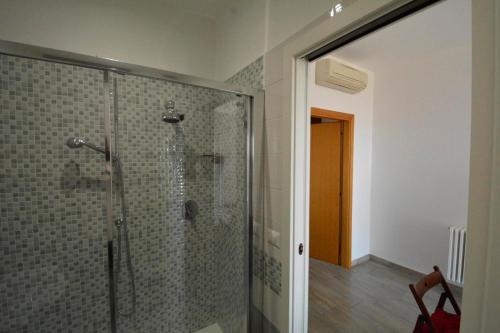 La salle de bains est pourvue d'une douche avec une porte en verre. dans l'établissement Appartamento Vistamare 20, à Bari