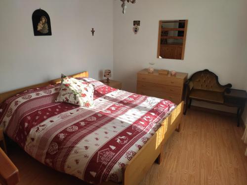 a bedroom with a bed with a red and white comforter at Casa Gemma in Vignola