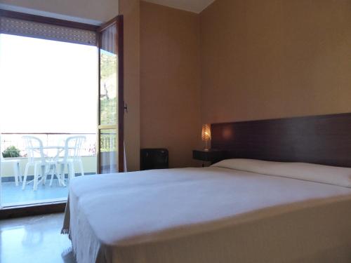 a bedroom with a large bed and a large window at Residence Green Park in Ventimiglia