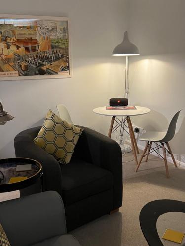 uma sala de estar com um sofá e uma mesa com um computador portátil em Atlantic apartment em Sidmouth