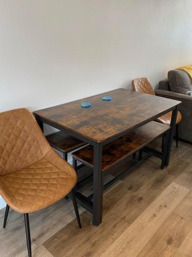 a wooden table with chairs and a couch at The Salty Bee in South Hayling