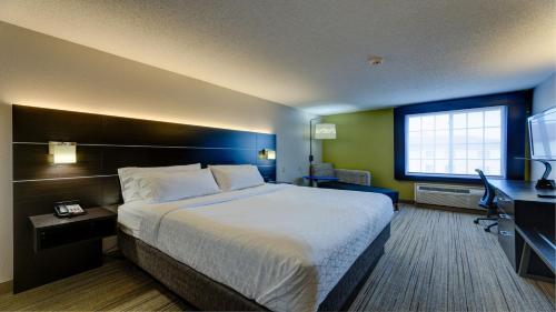 um quarto de hotel com uma cama grande e uma secretária em Holiday Inn Express & Suites Ashtabula-Geneva, an IHG Hotel em Austinburg