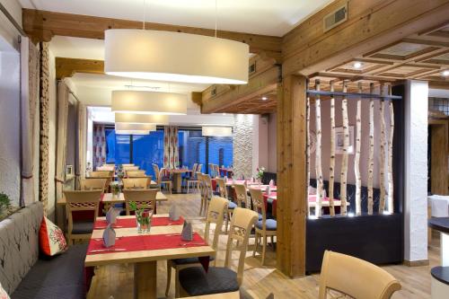 アーレンにあるHotel-Restaurant Vogthofの木製の壁とテーブルと椅子が備わるレストラン