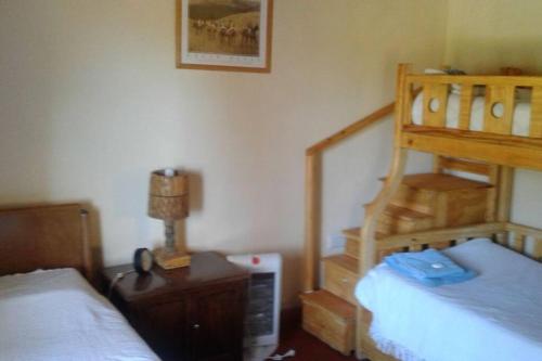 1 dormitorio con 2 camas y 1 litera de madera en Lo de Jorge en Payogasta