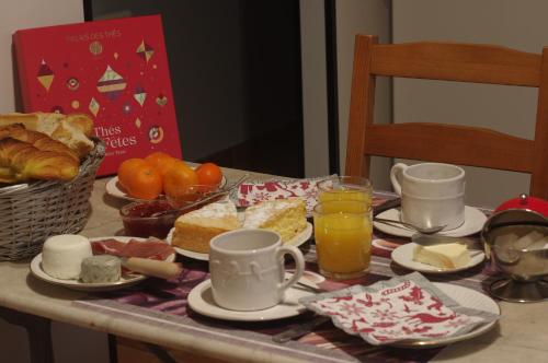 - une table avec petit-déjeuner composé de nourriture et de jus d'orange dans l'établissement La Pause 18, à Jars