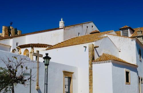 a white building with a street light in front of it at Casa Saudade luxury rooms in Faro