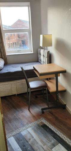 a desk and a chair in a room with a window at En suite single bedroom, close to city centre in Sheffield