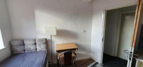 um quarto com uma cama e uma mesa com um candeeiro em En suite single bedroom, close to city centre em Sheffield