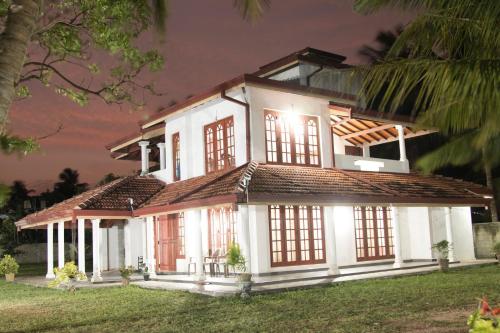 a large white house with a lot of windows at Joy Lagoon Residence in Negombo