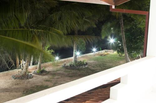 a view of a park with palm trees at night at Joy Lagoon Residence in Negombo