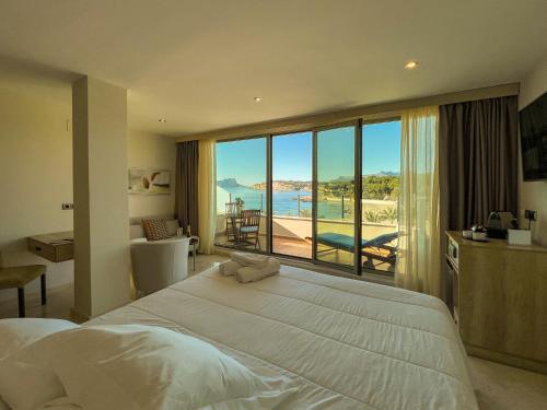 
a hotel room with a bed and a window at La Sort Boutique Hotel in Moraira
