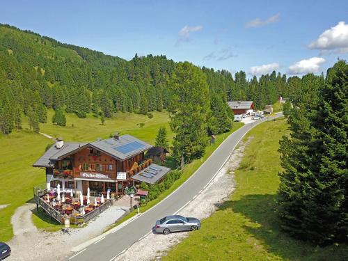 a car parked in front of a house on a road at Edelweißhütte in Funes