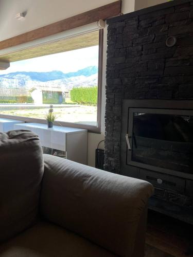 a living room with a couch and a large window at El Llano in Candeleda