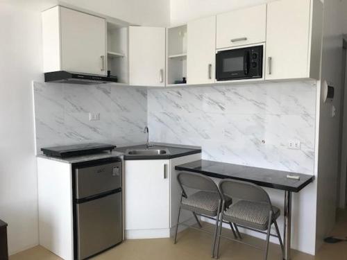 a kitchen with a counter and two chairs and a table at I love this place for my home while staying in Cagayan de Oro City in Cagayan de Oro