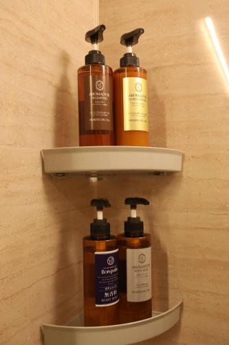 a group of four bottles of soap on a shelf at Hotel Charire Kichijoji in Kichijōji