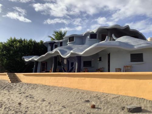 une maison sur la plage à côté d'un bâtiment dans l'établissement Melting Elefante, à Popoyo