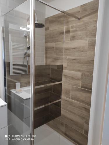 a bathroom with a shower with a glass door at Appartement de charme in Courseulles-sur-Mer