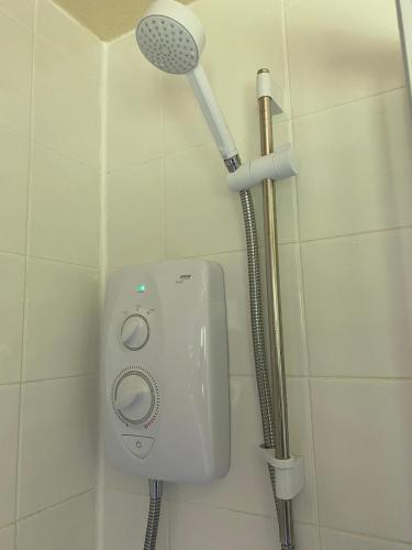 a shower with a shower head in a bathroom at Detached Bungalow in North Cornwall in Bodmin