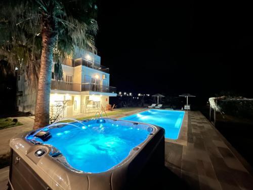 a swimming pool at night next to a building at Martimi Apartments in Kissamos