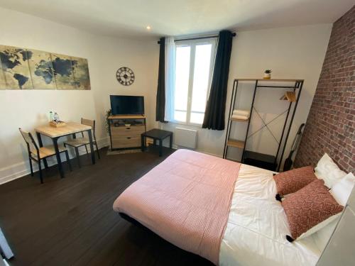 - une chambre avec un lit, une table et une fenêtre dans l'établissement Le Petit Cerf 3 / Proche Disney / Paris / Wifi, à Meaux